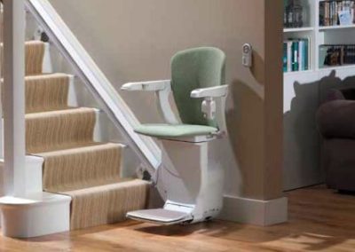 A green chair sitting on top of a white stair.