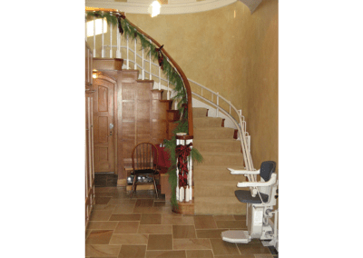 A staircase with a chair and stair lift.