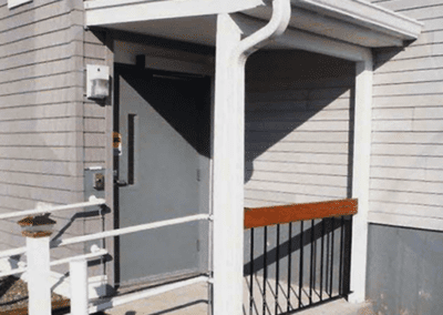 A porch with a railing and a door.