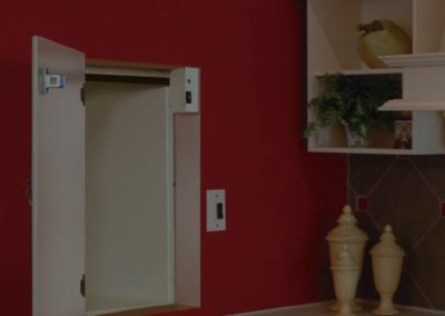 A red wall with a white cabinet and two vases.